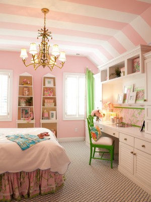 Murs roses et rayures blanches et roses au plafond avec des petits détails verts dans la pièce