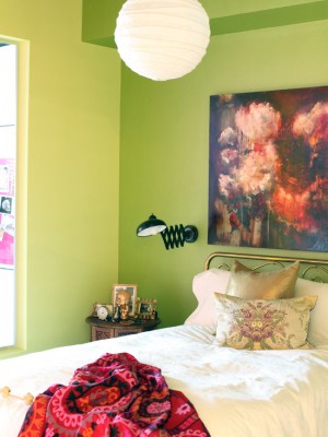Chambre vert clair avec un lit en fer